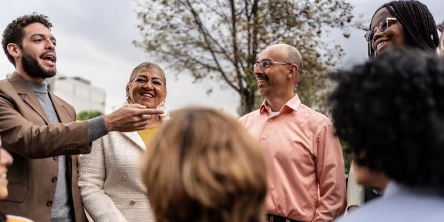 A community manager talking with a group of people in an outdoor setting.