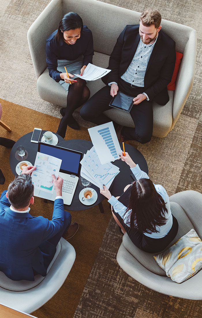 Group of people sitting around a table with papers on it