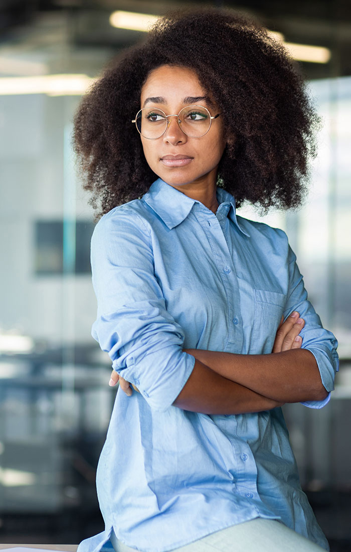 Female professionak looking aside with crossed arms on chest.