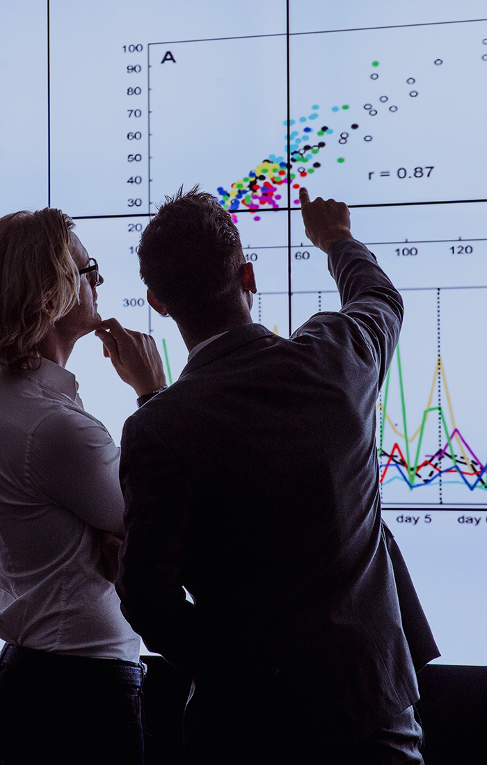 A man and a woman looking at data on the digital display.