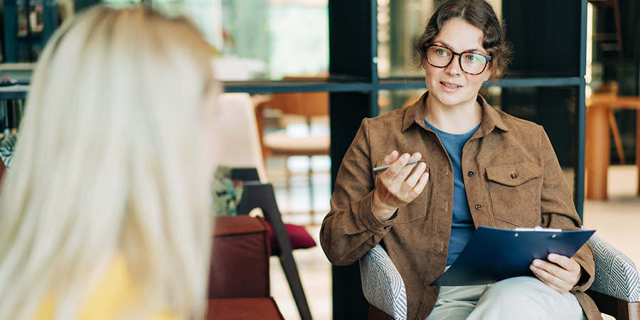 A behavior analyst meets with a client in a private office.