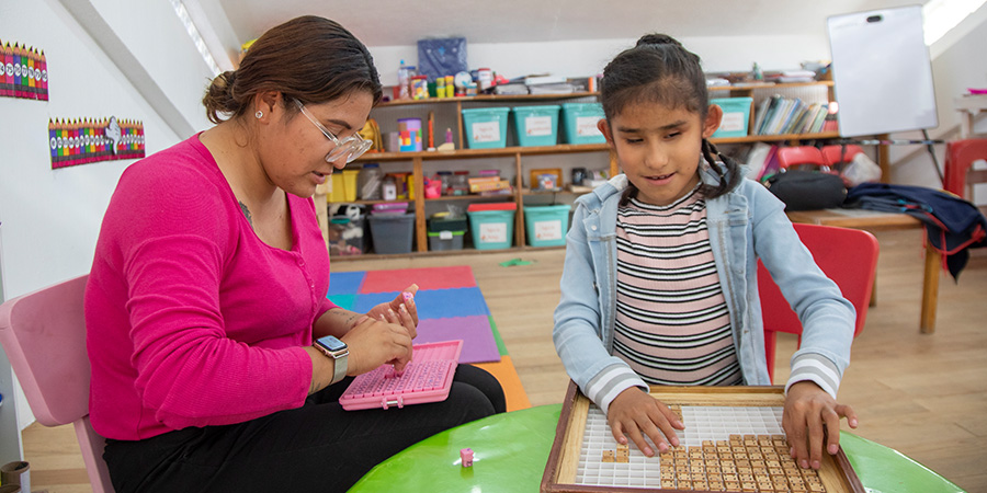 An assistive technology specialist helps a child with blindness learn math.